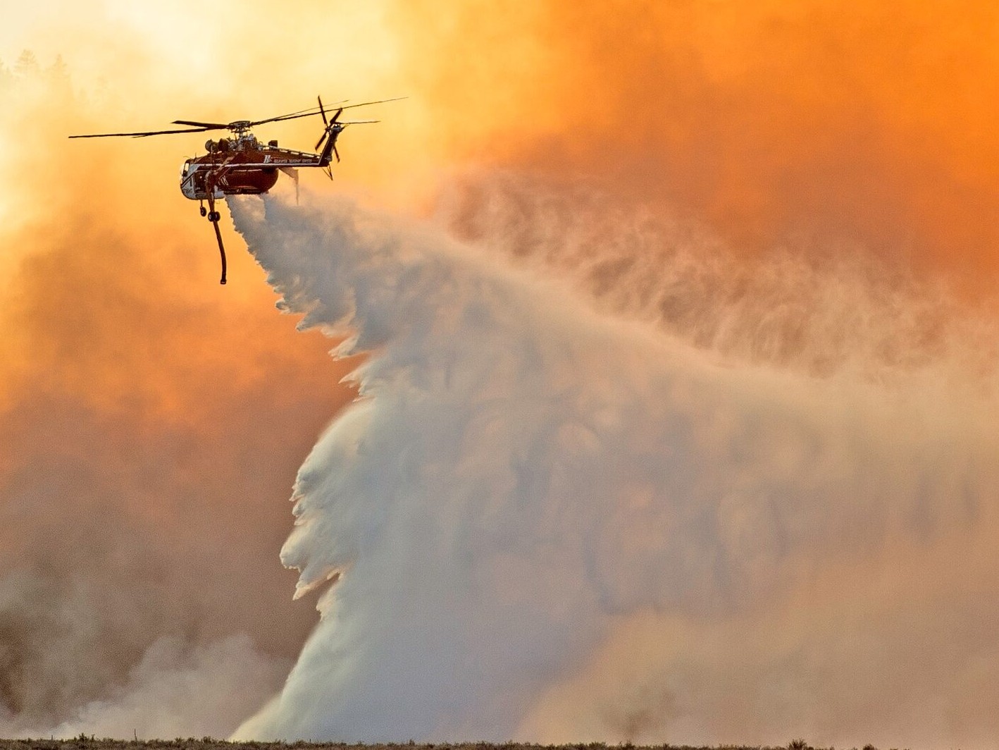 A Sikorsky S-64 "Skycrane" capable of carrying nearly 3,000 gallons of water makes a drop along the southwest edge of the Owens River fire Saturday afternoon.
Photo by Mike Chacanaca